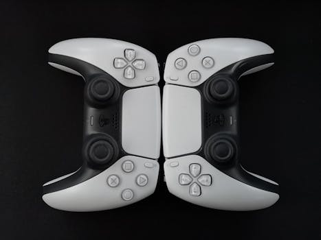 Top-down view of two modern white gaming controllers on a black surface.