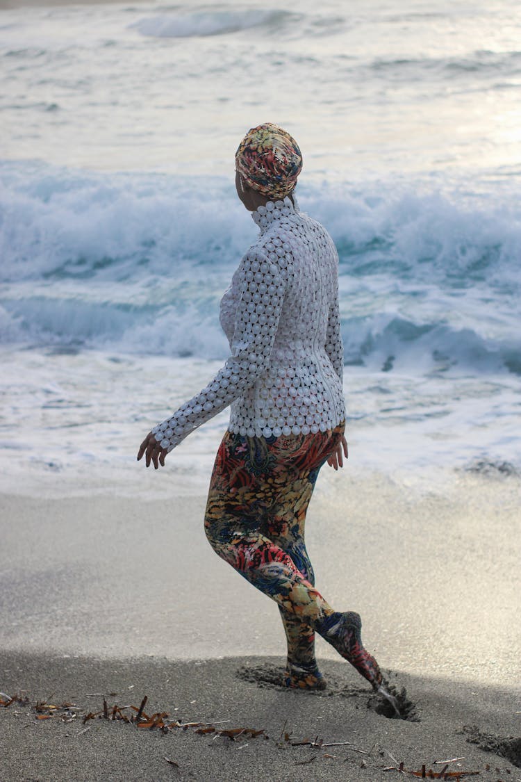 Woman Walking On Sand Beach On Sunset