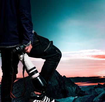 Dynamic image of a photographer with a telephoto lens at sunset.