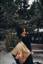 Woman Holding a Paper Bag with Spruce Twigs