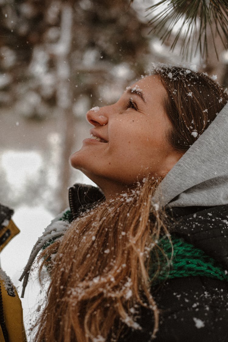 Woman Tilting Her Face To The Falling Snow