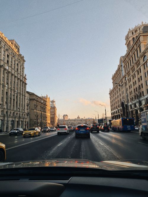 Free View of busy city road with vehicles and historic buildings under clear sky in Moscow. Stock Photo