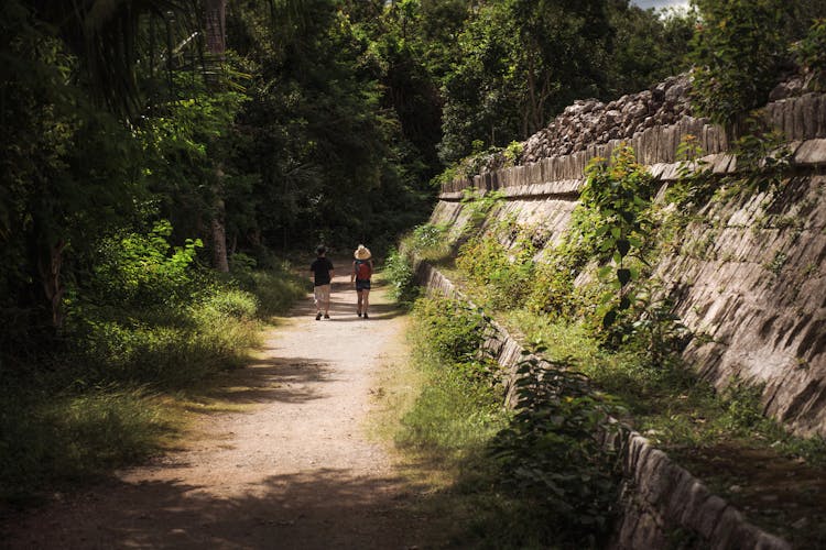 Tourists Sightseeing Ruins Of Ancient City In Jungle 