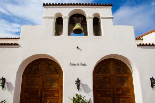 Free A stunning Spanish-style structure with intricate wooden doors and a prominent bell. Stock Photo