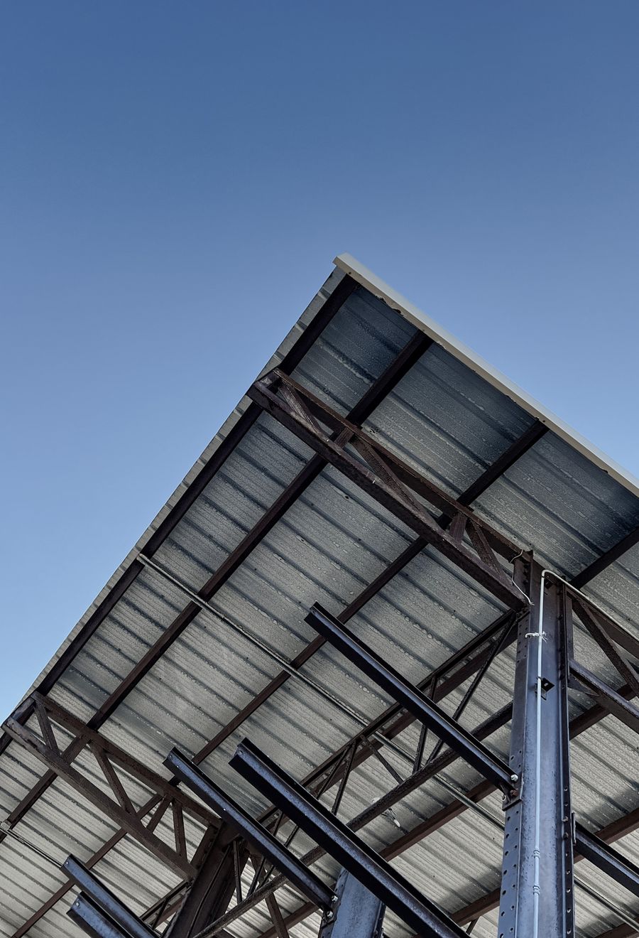 Steel frame structure under construction against a blue sky