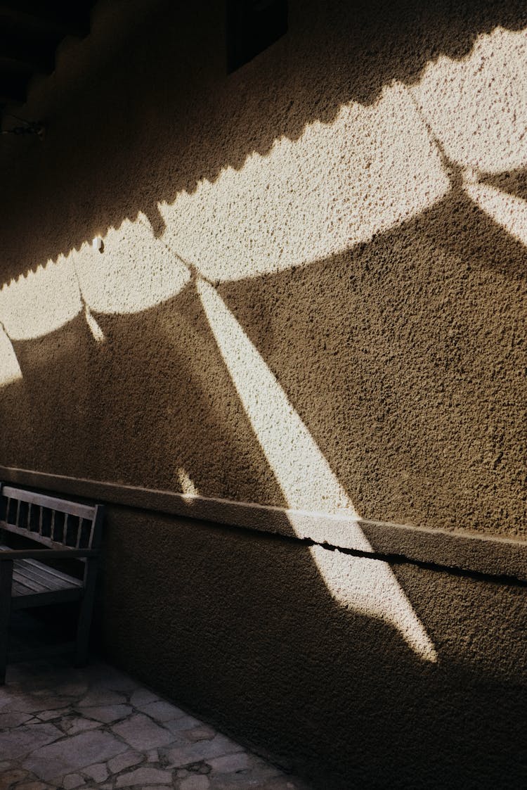 Shadow Of Sunblinds On Building Wall In Narrow Street