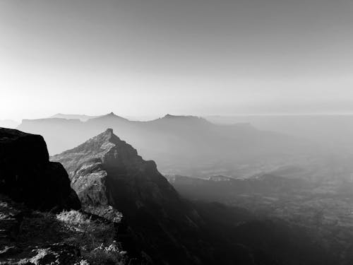 A Grayscale Photo of a Mountains Under the Clear Sky