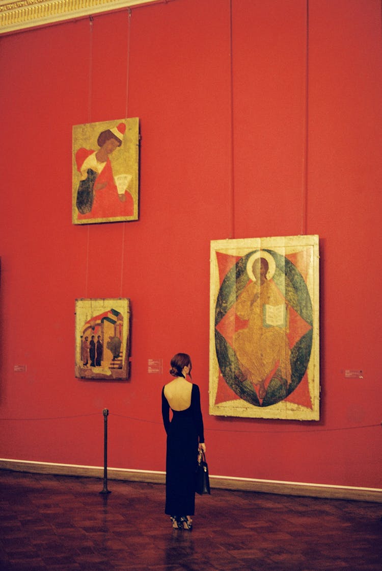 Tall Woman In Black Dress Looking At Icon In Museum