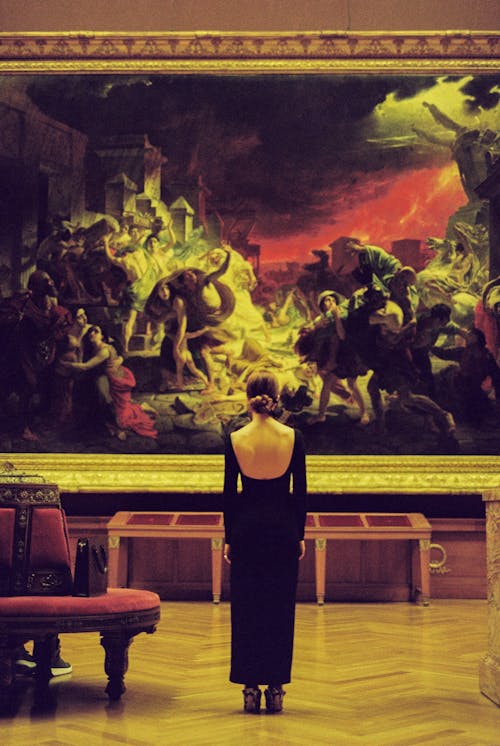 Free Woman in Black Dress Standing in Front of a Painting Stock Photo