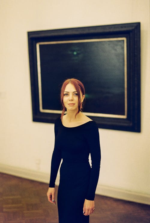 Free Woman in Black Long Sleeve Shirt Standing Near a Painting Stock Photo
