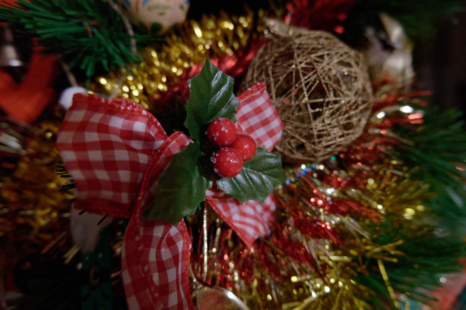 Décoration de Noël avec nœud vichy rouge, baies de houx et guirlande dorée