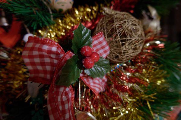 Décoration de Noël avec nœud vichy rouge, baies de houx et guirlande dorée