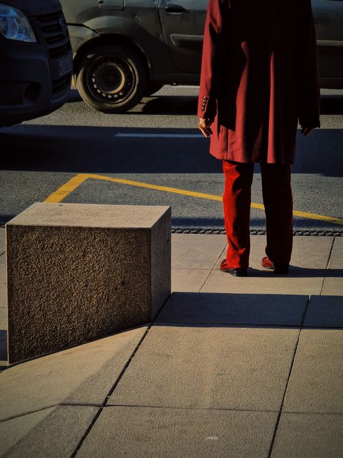 Free A person in red stands near a street in Краснодар, Россия, capturing urban life. Stock Photo
