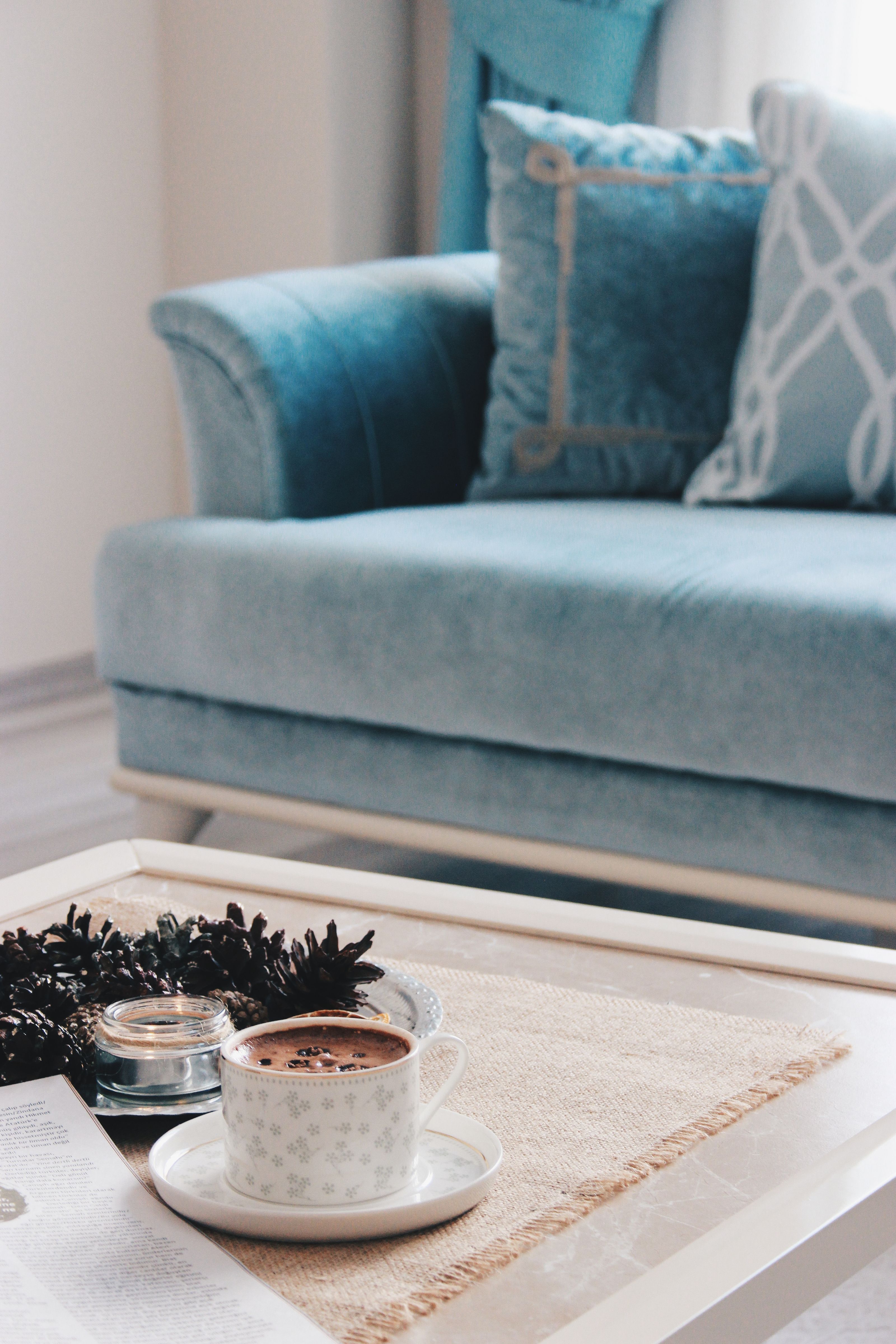 Ambiente confortável de sala de estar com um copo de café em uma mesa branca, perfeito para relaxar.