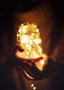 Person Holding Clear Glass Jar With Lighted String Lights