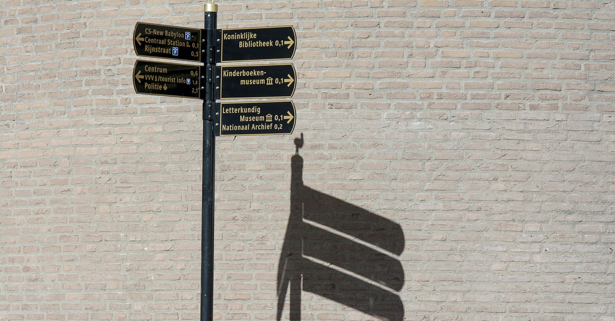 a wooden signpost with arrows pointing many ways