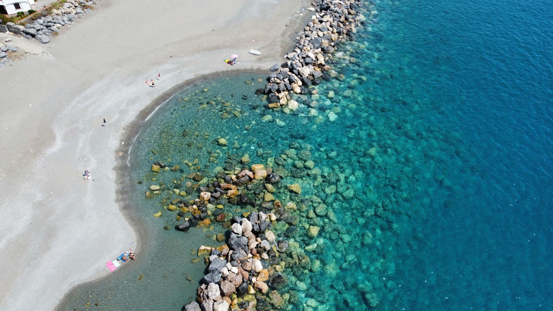 Explore the crystal-clear waters and sandy shores of Calabria's stunning coast from above.
