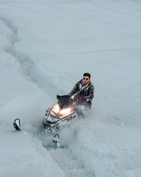 Thrilling snowmobile ride across snow-covered landscapes in Gulmarg, showcasing winter adventure sports.