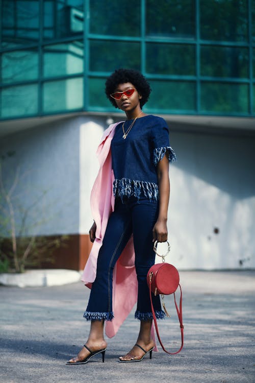 Shallow Focus Photography of Woman in Blue Clothes Holding Red Leather 2-way Handbag