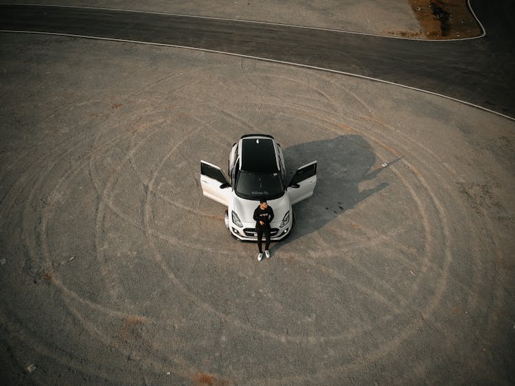 Man Sitting On Car Hood In Aerial Photography