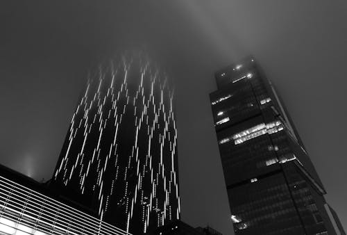 A Grayscale Photo of a Modern Buildings at Night