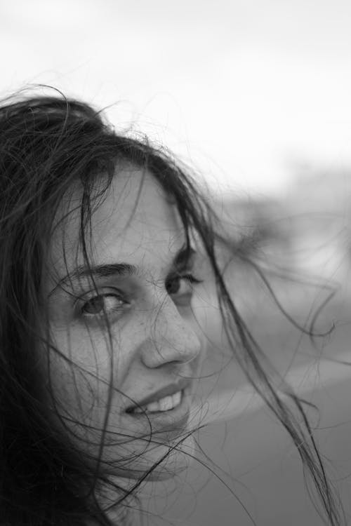A Grayscale Photo of Woman's Face with Messy Hair