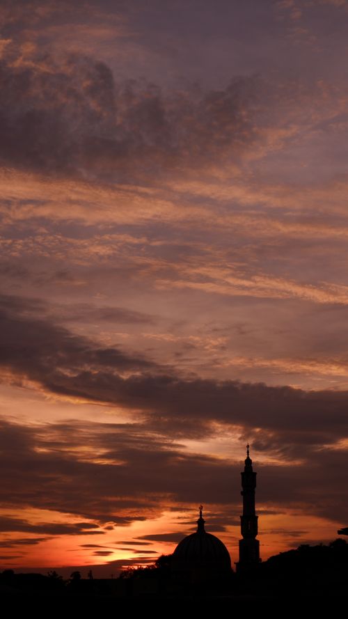 Free A mosque silhouette during a vibrant sunset, capturing dramatic skies and tranquility in Indonesia. Stock Photo