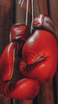 Close-up of vibrant red boxing gloves hanging inside, emitting a dramatic and sporty vibe.