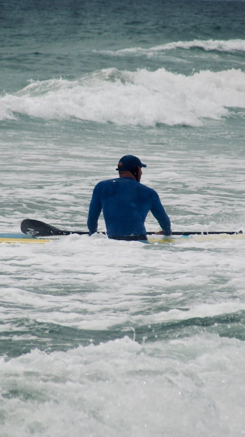 Man in Blue Wetsuit Holding Paddle