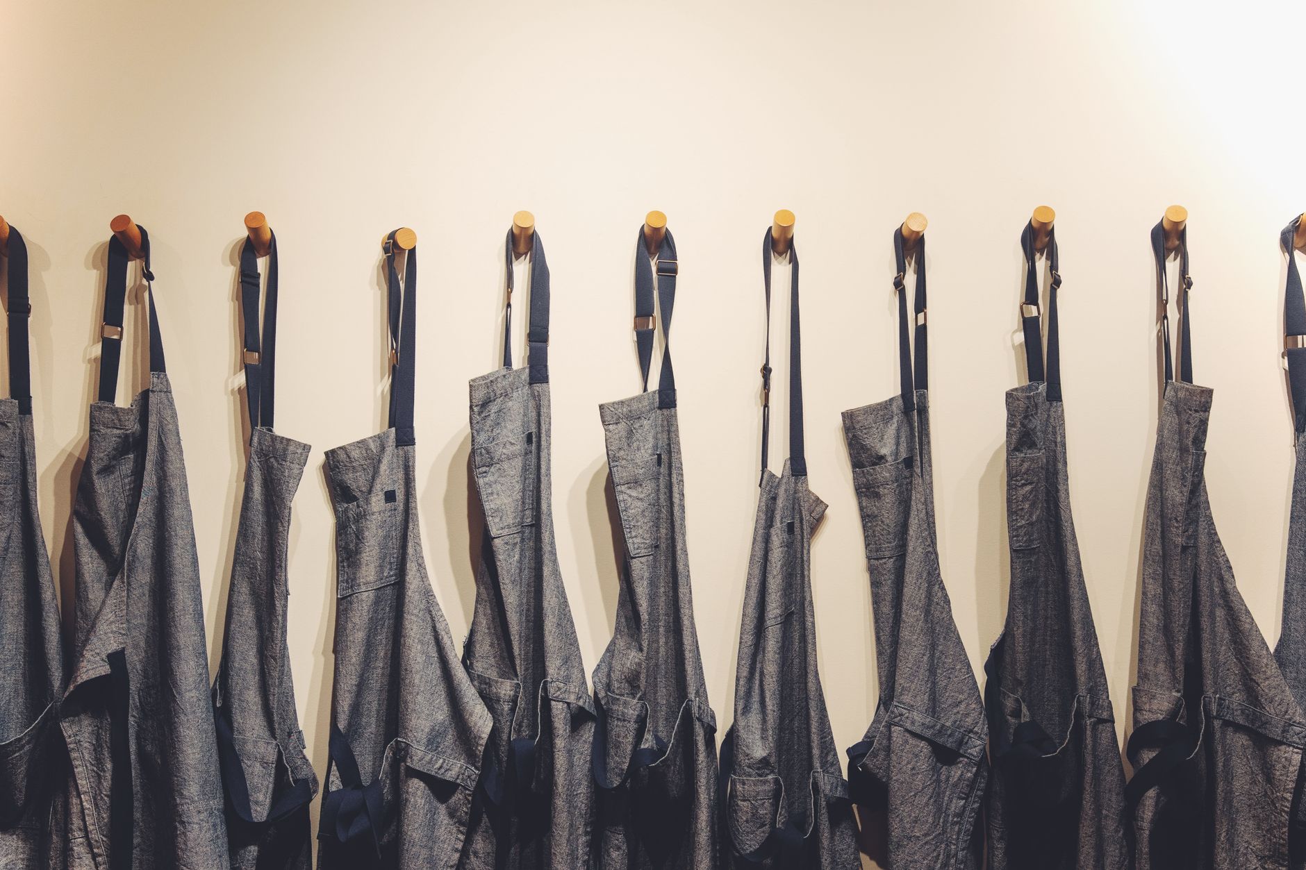 Four garments hung or laid flat after a 30-minute recovery period, showing varying degrees of wrinkle self-release between wool, wool-polyester blend, viscose, and ponte fabric types, demonstrating how elastic recovery determines which creases self-correct versus which require steamingSOURCE: Unsplash