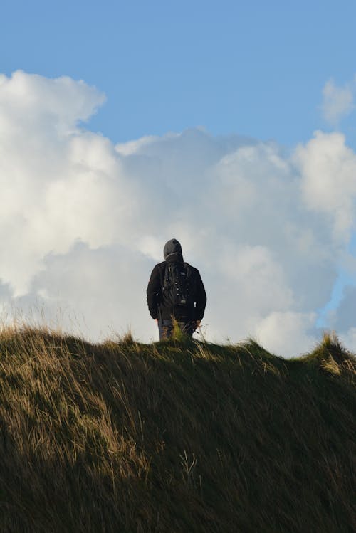 Man in Black Jacket Standing on Hill Top