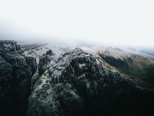 Free Aerial view of a fog-covered rocky mountain landscape during winter. Stock Photo