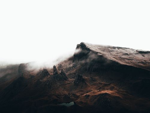 Free Foggy mountain peak with geological formations in a misty Highland landscape. Stock Photo