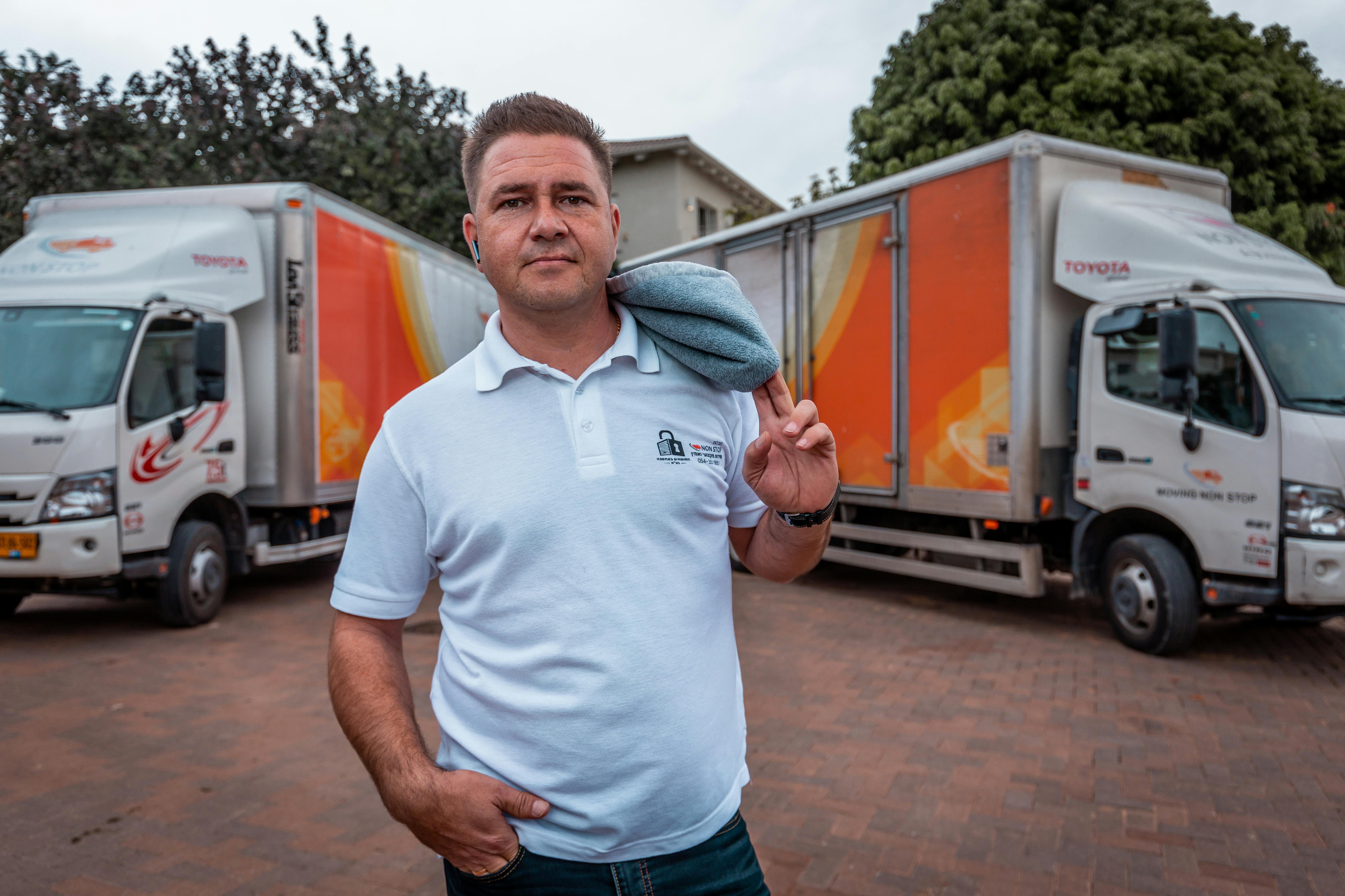 man in blue polo shirt standing near white van