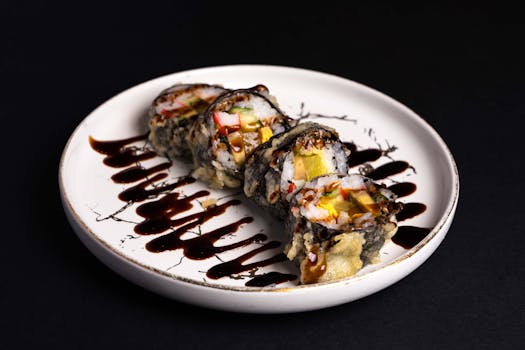 Elegant sushi rolls served with a drizzle of savory sauce on a stylish plate against a dark background.