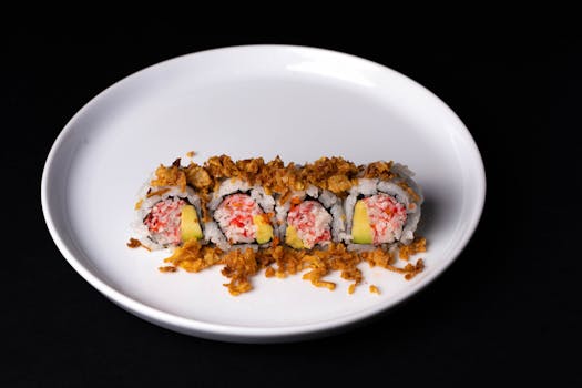 Tasty sushi roll topped with crispy flakes and served on a white plate, perfect for food lovers.