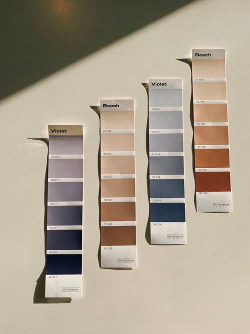 Free Vertical color swatches showcasing beach and violet shades under natural light on a neutral surface. Stock Photo