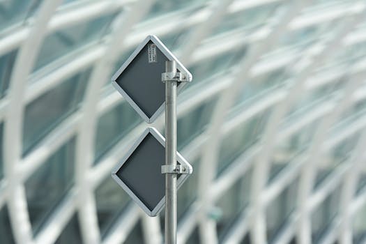 Close-up of a modern street sign against an architectural background, highlighting design.