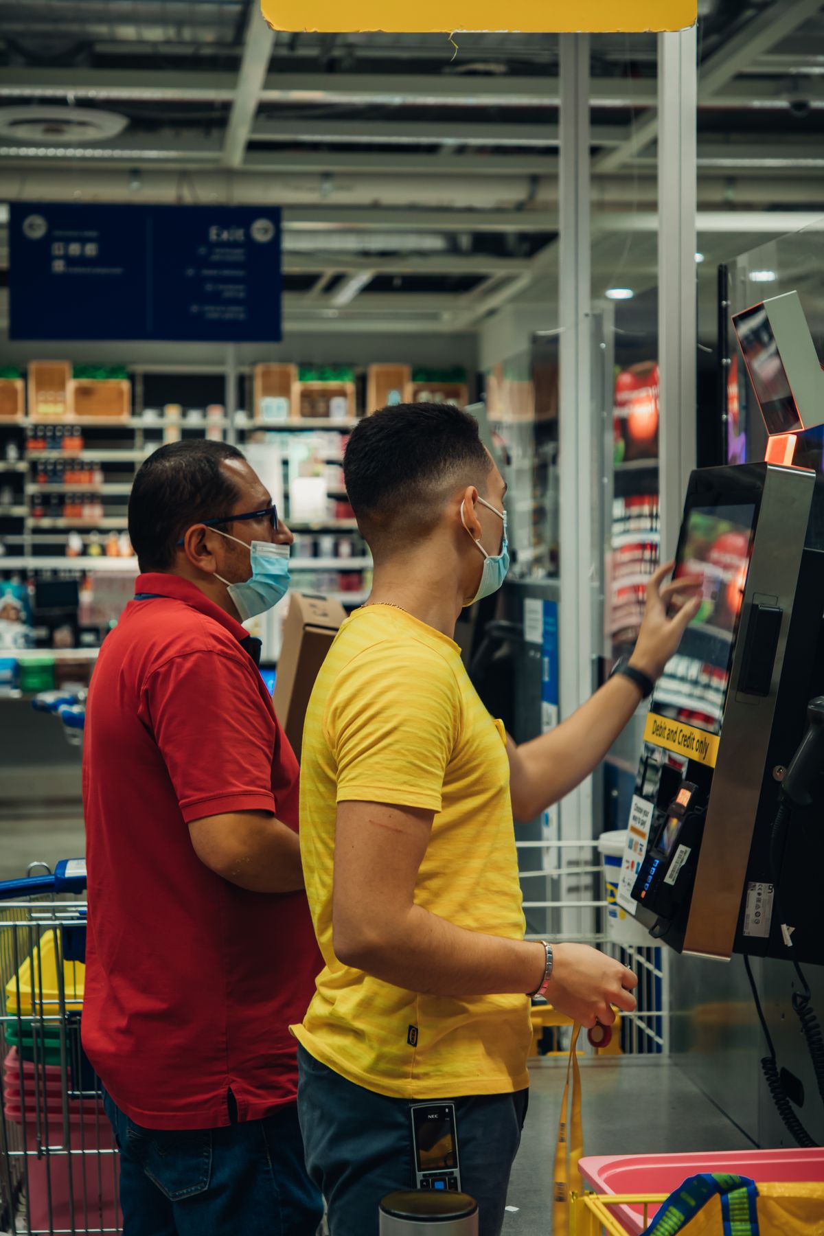 Clientes usando equipamento de autoatendimento em uma loja de varejo alimentar