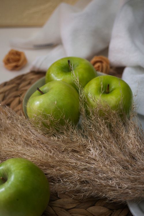 Free Aesthetic close-up of green apples paired with decorative autumn elements. Stock Photo