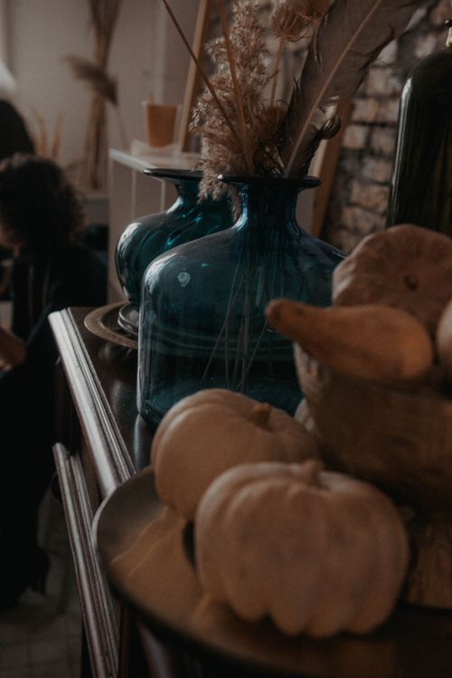 Free Warm autumn-themed still life with glass vases and gourds, perfect for cozy interior settings. Stock Photo