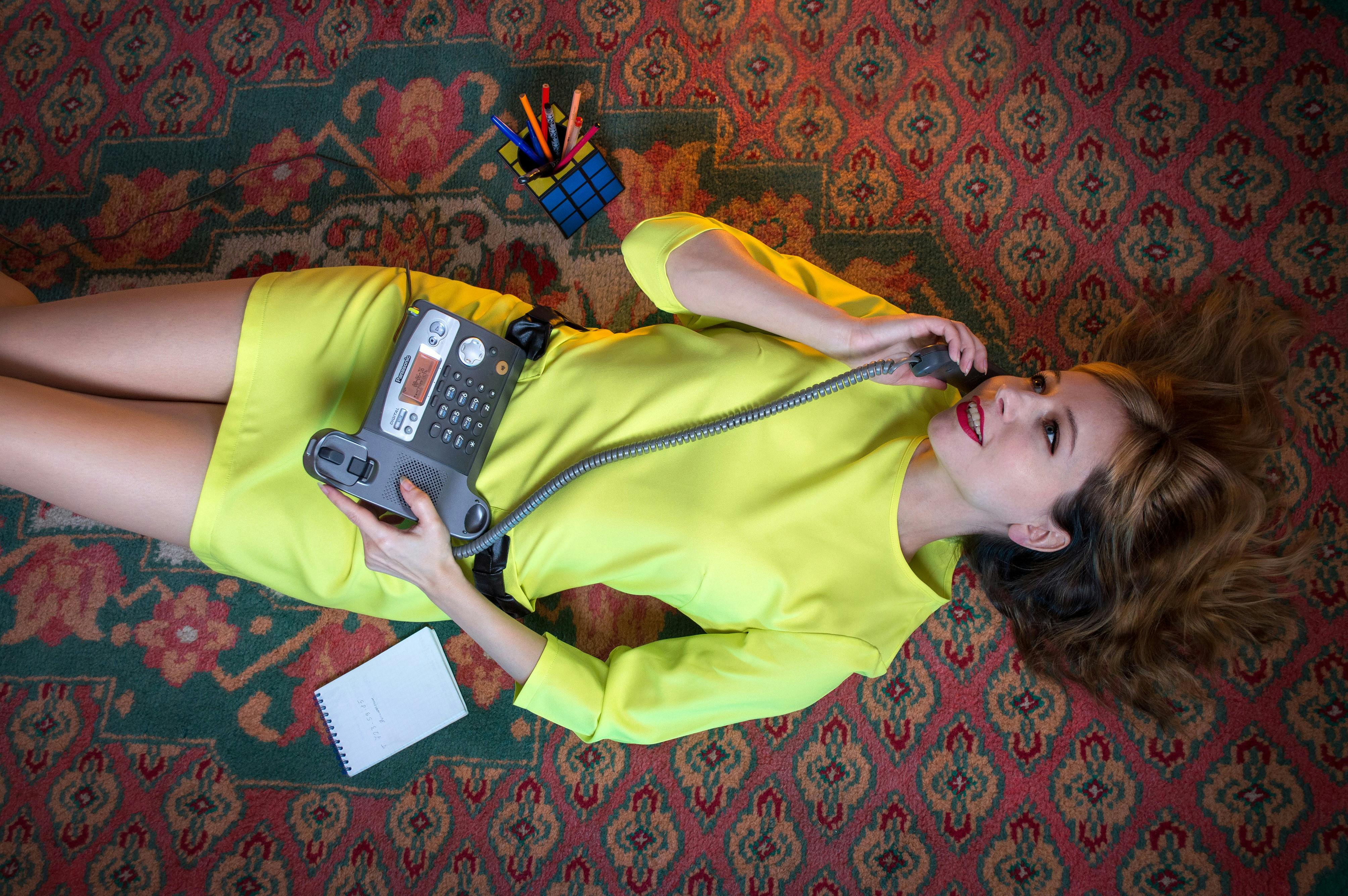 A Woman Lying Down on the Floor While using Telephone · Free Stock Photo