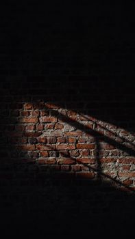 A brick wall captured with striking sunlight and shadows creating a dramatic contrast.