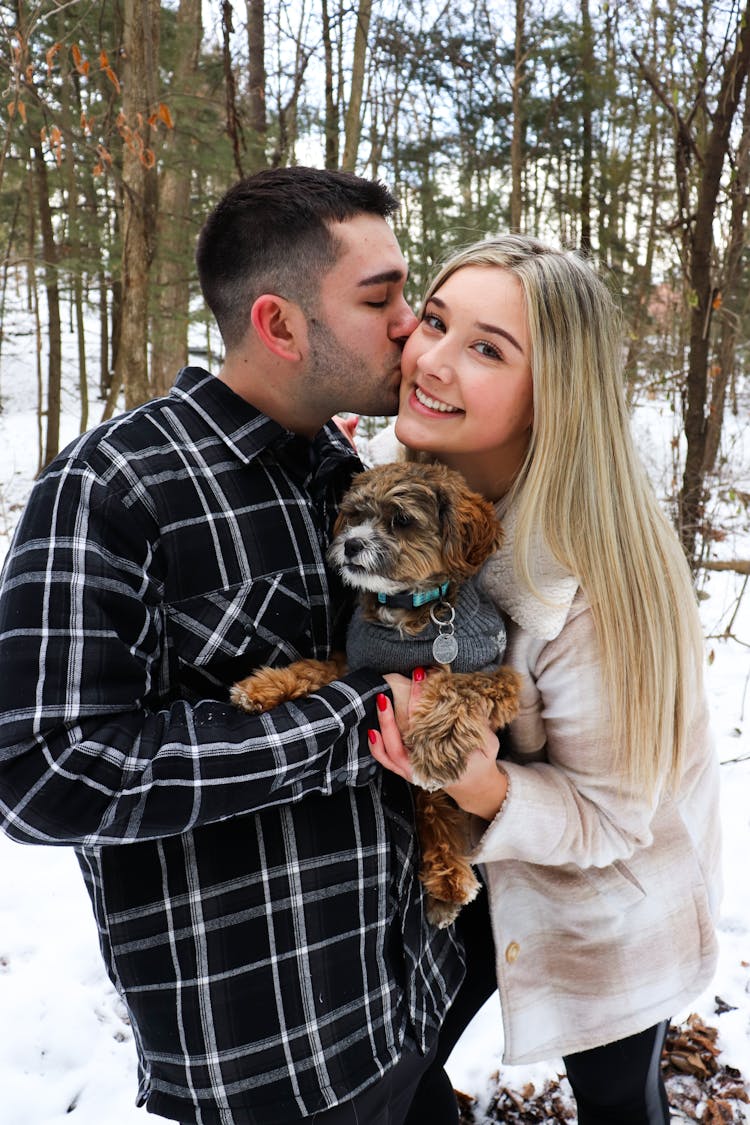 Couple Posing With Dog In Forest In Winter