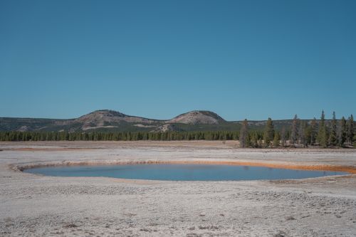 Free Explore the serene geyser basin with clear blue sky in Yellowstone National Park. Stock Photo