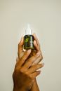 Person Holding a Facial Oil Bottle