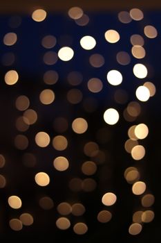 Warm golden bokeh lights against a deep blue background create a serene ambiance.