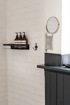 Chic minimalist bathroom featuring white brick tiles and stylish black fixtures.
