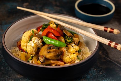 Free Colorful vegetable stir fry with rice in a bowl, adorned with chopsticks. Perfect for healthy eating. Stock Photo
