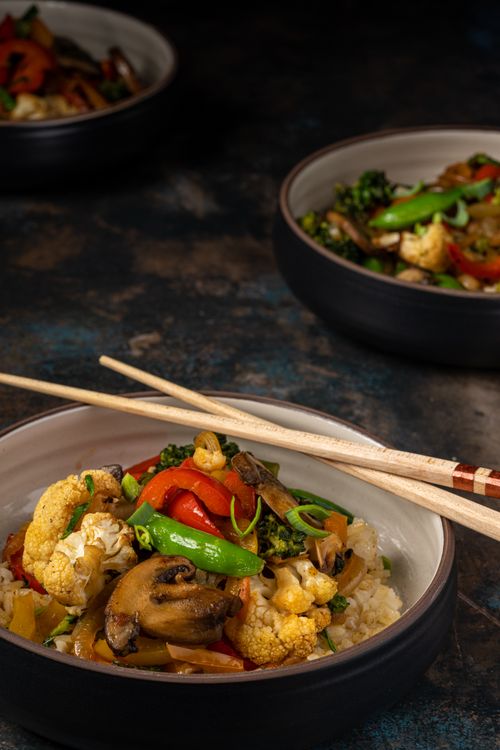 Free Delicious and colorful mixed vegetable stir fry with rice, served with chopsticks for a healthy meal. Stock Photo